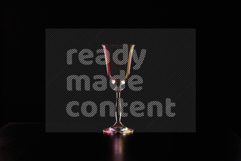 Glassware with rim light in red and yellow against black background