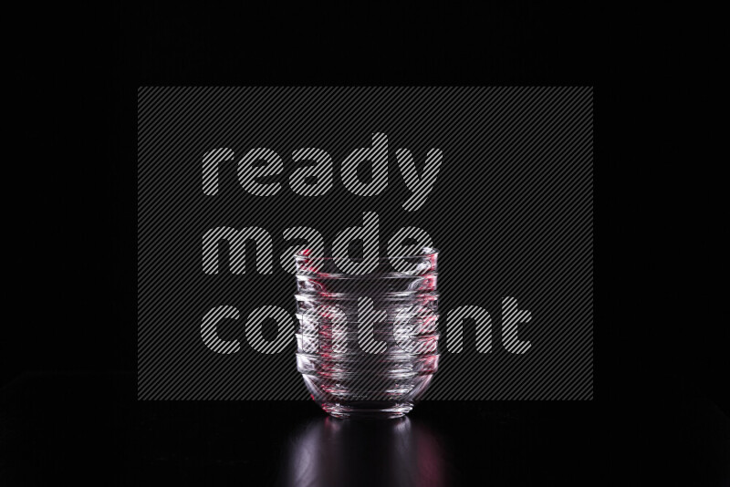 Glassware with rim light in red and white against black background