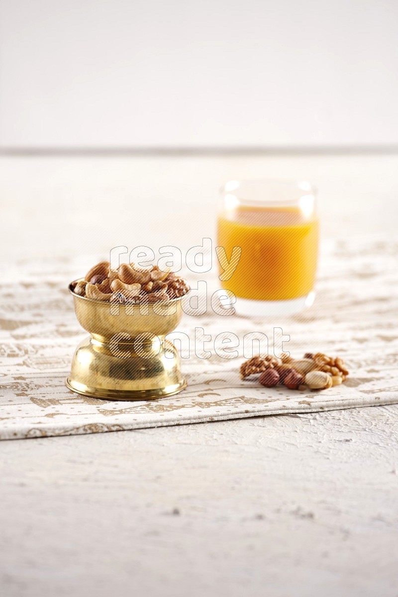 Nuts in a metal bowl with qamar eldin in a light setup