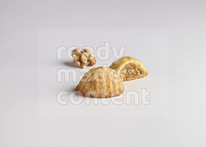 Two Pieces of Maamoul filled with walnut paste  one of them is cut direct on white background