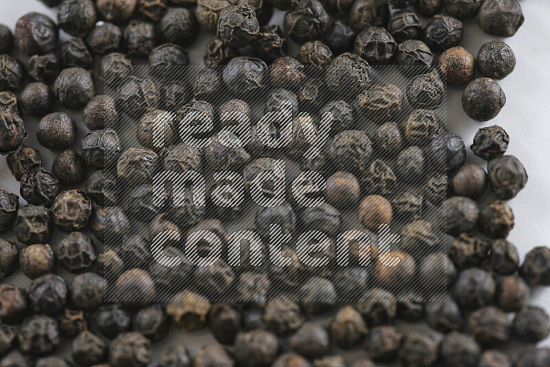 Black pepper beads on white background