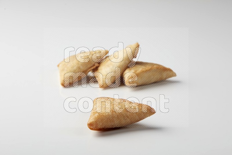 Four fried sambosas on a white background