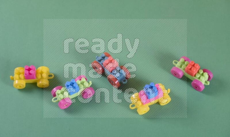 سيارات لعبة صغيرة مصنوعة من البلاستيك علي خلفية صفراء وخضراء (ألعاب أطفال)