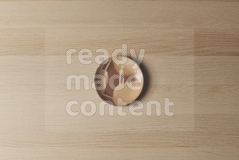 A multicolored pottery plate on light wooden background