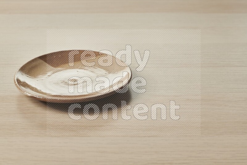 A multicolored pottery plate on light wooden background