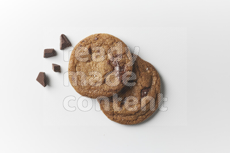 Chocolate chips cookies with chocolate beside it on a white background