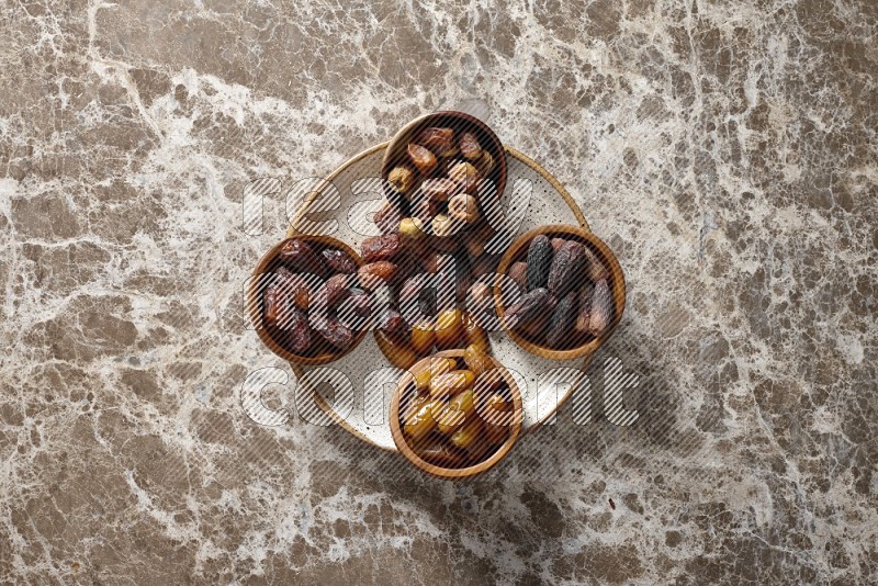 Dates in pottery plates and wooden bowls in a light setup