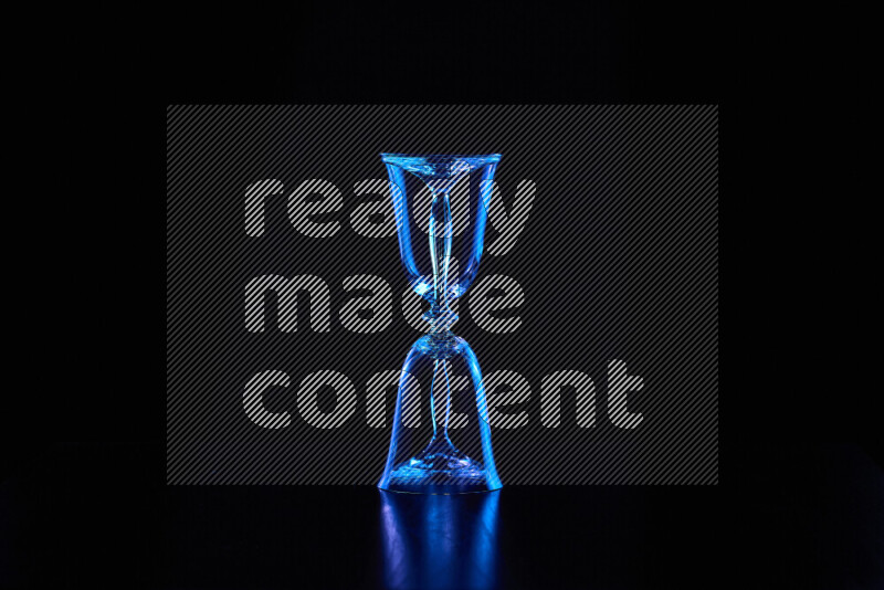 Glassware with rim light in blue against black background