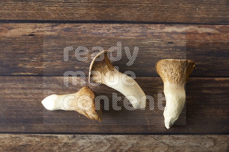 Fresh King oysters mushrooms topview on a wooden background