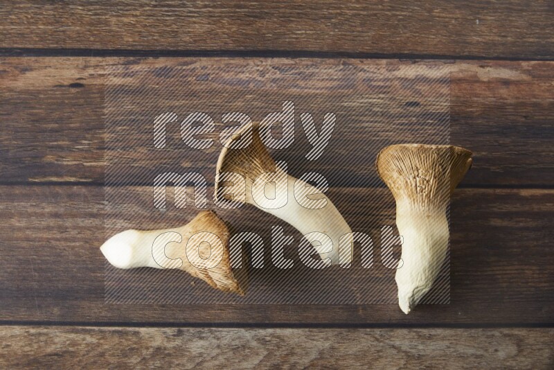Fresh King oysters mushrooms topview on a wooden background