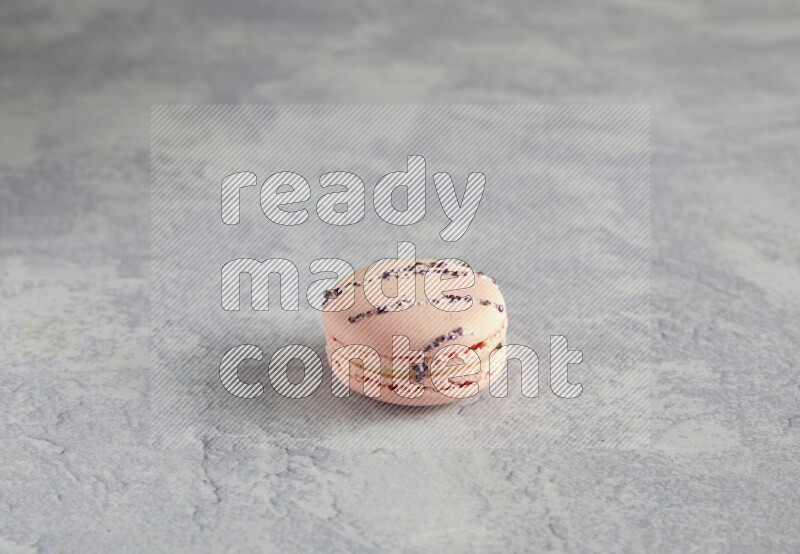 45º Shot of pink orange blossom macaron on white  marble background