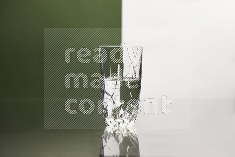 The image features a clear glassware filled with water, set against white and dark green background