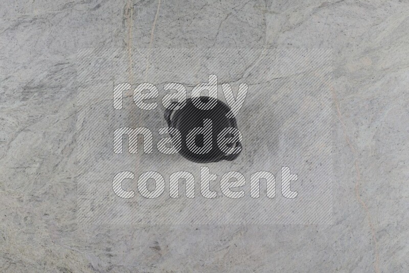 A black pottery bowl on grey marble background