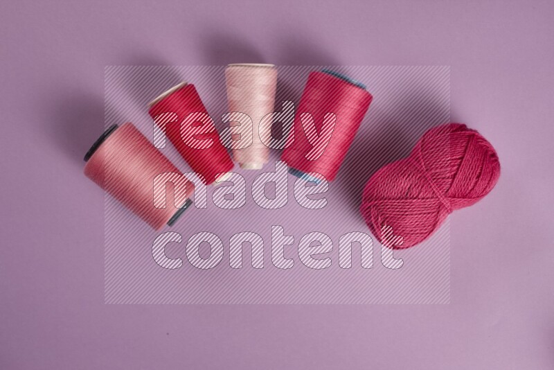 مجموعة من أدوات الخياطة والتفصيل زهرية وأرجوانية اللون على خلفية أرجوانية