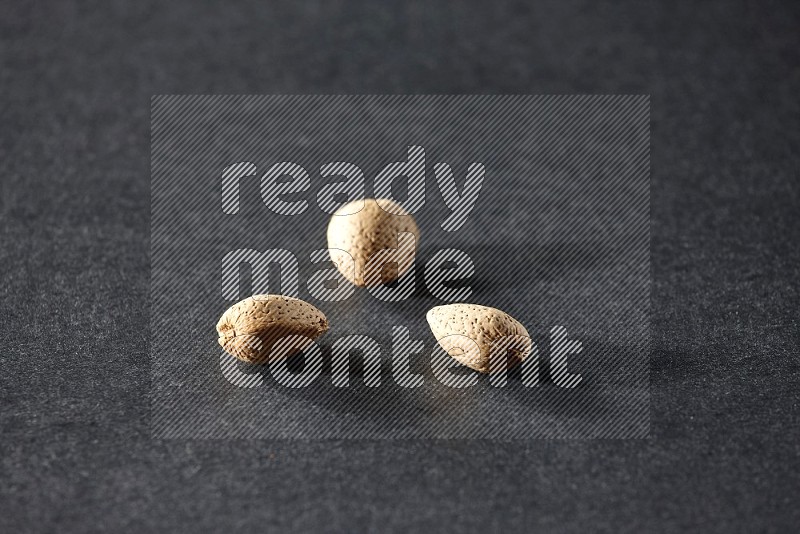 3 almonds on a black background in different angles