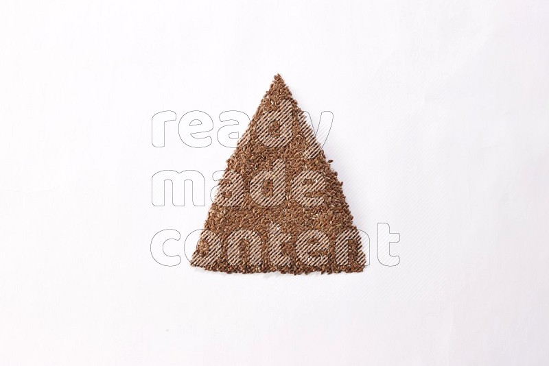 Flax seeds in a triangle shape on a white flooring