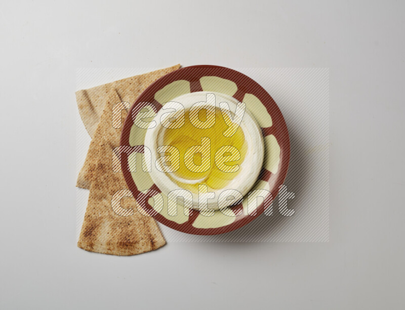 Lebnah garnished with olive oil in a traditional plate on a white background