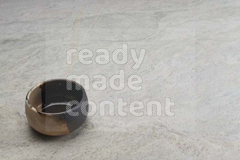 A multicolored pottery bowl on grey marble background