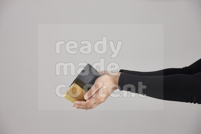 A woman in black abaya holding different pottery essentials in different positions