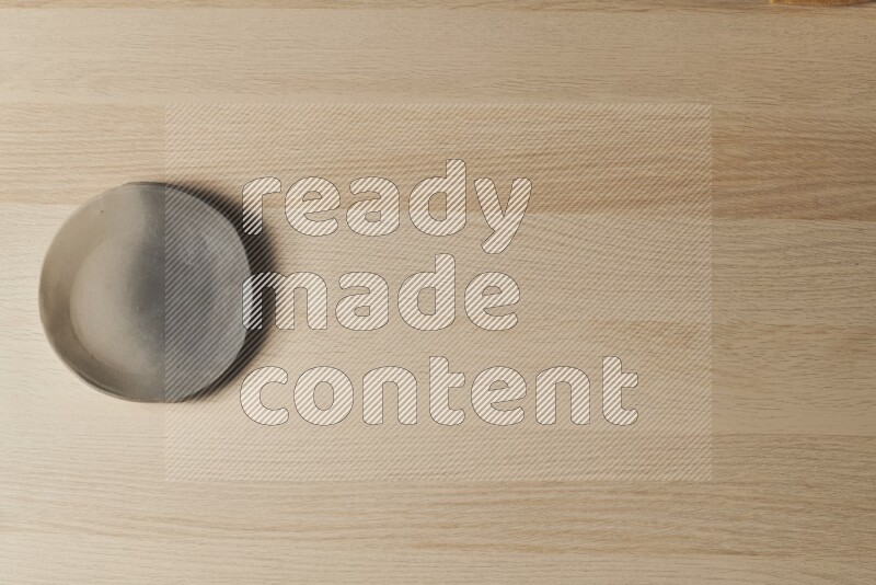 A multicolored pottery plate on light wooden background