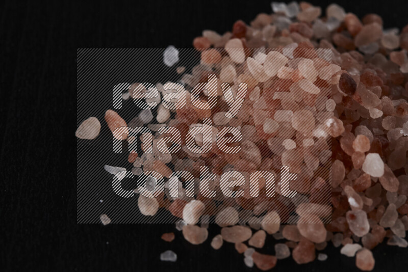 A bunch of coarse himalayan salt crystals on black background