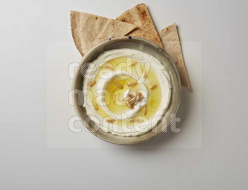 Lebnah garnished with pine nuts in a grey pottery plate on a white background