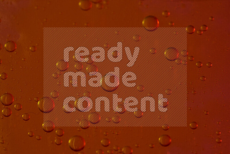 لقطات مقربة لقطرات من الماء على سطح الزيت على خلفية حمراء