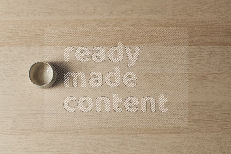 A multicolored pottery bowl on light wooden background