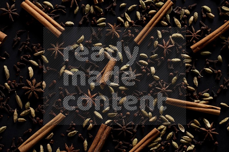 Cinnamon Sticks, Star anise, Cardamom and cloves on a black background