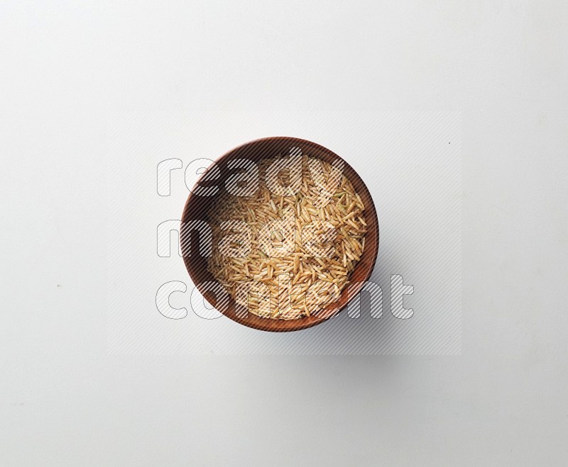 Top-view shot of long grain brown rice in a container on white background