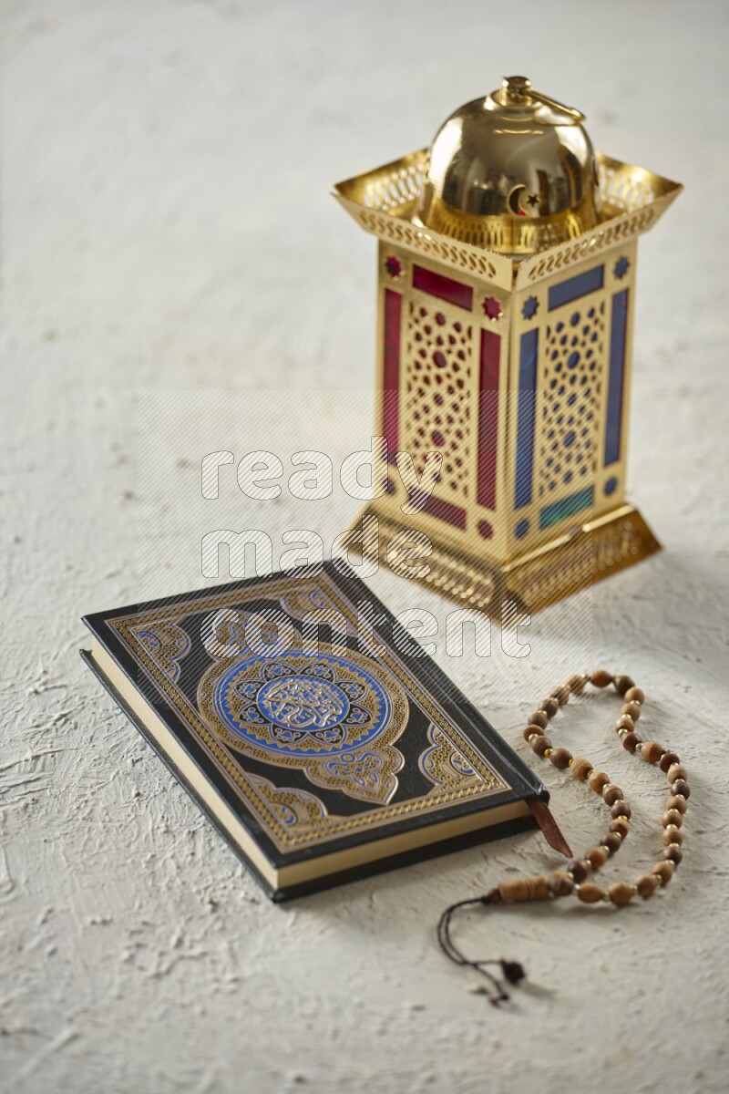 A golden lantern with different drinks, dates, nuts, prayer beads and quran on textured white background