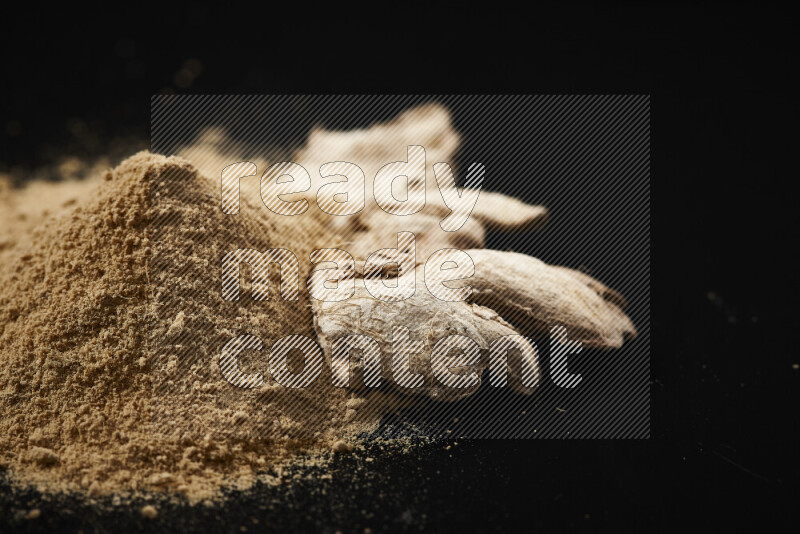 A bunch of ground ginger powder on black background