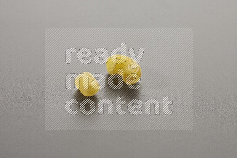 Big rings pasta with other types of pasta on grey background