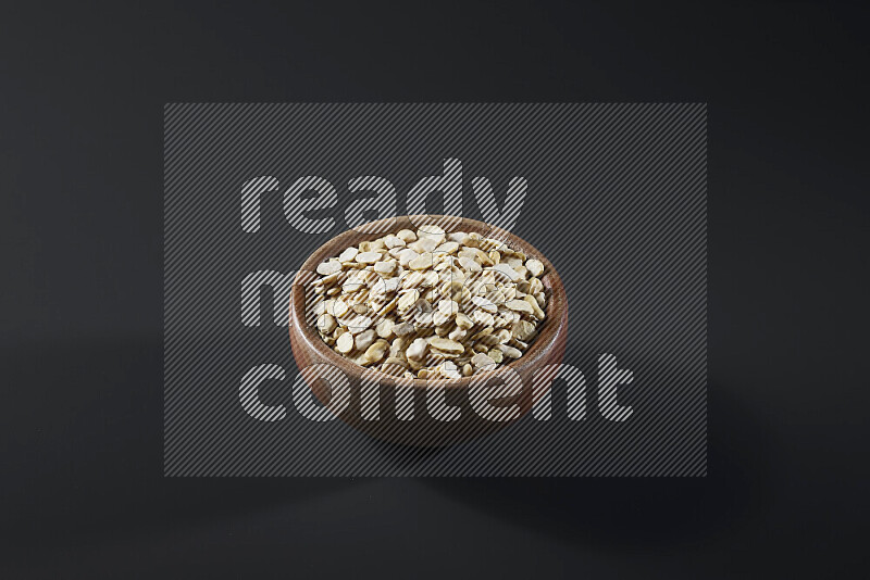 Crushed beans in a wooden bowl on grey background