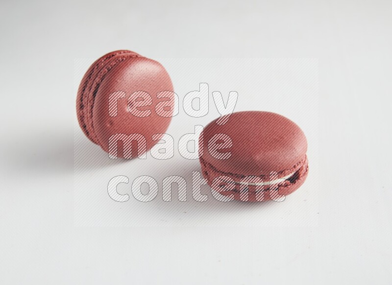 45º Shot of two Red Velvet macarons on white background