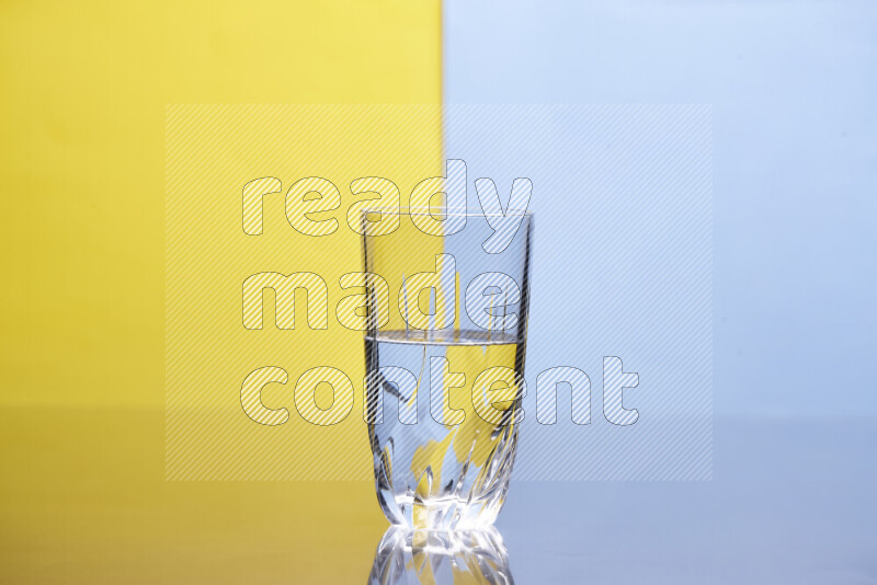 The image features a clear glassware filled with water, set against yellow and light blue background