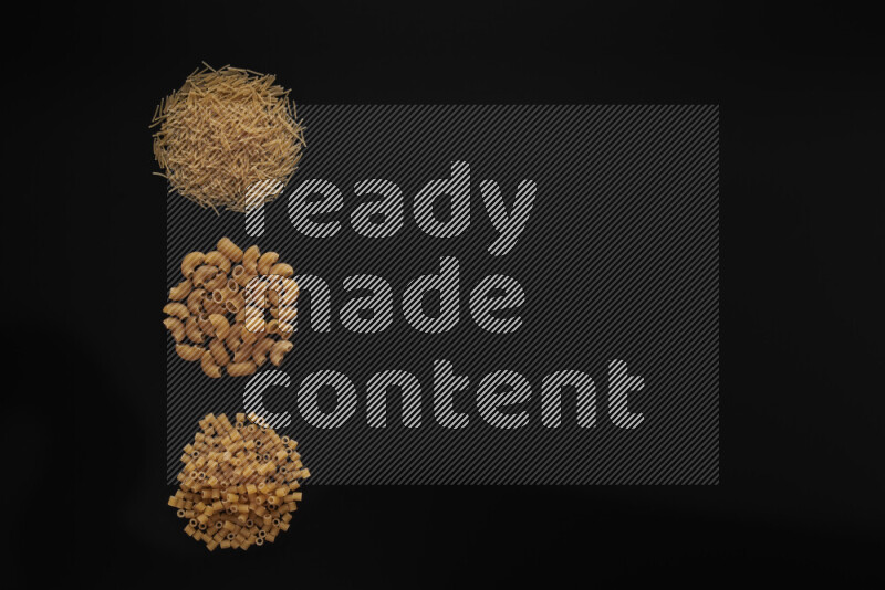 Different pasta types in 3 bunches on black background