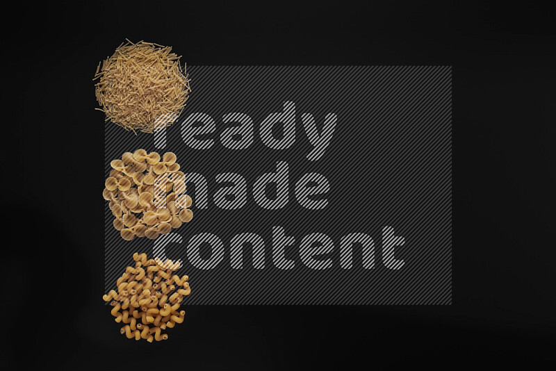 Different pasta types in 3 bunches on black background