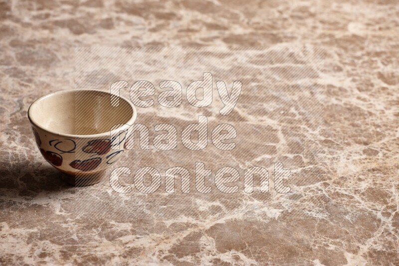 A decorative pottery bowl on beige marble background