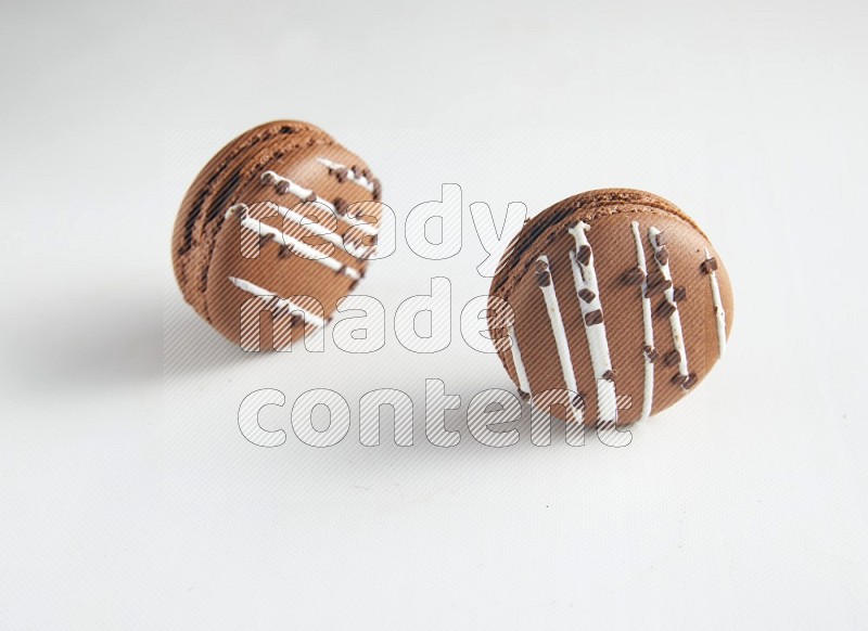 45º Shot of two Brown white Chocolate Caramel macarons on white background