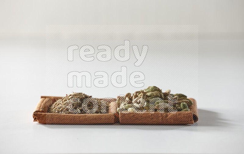 2 squares of cinnamon sticks full of cardamom and cumin on white flooring