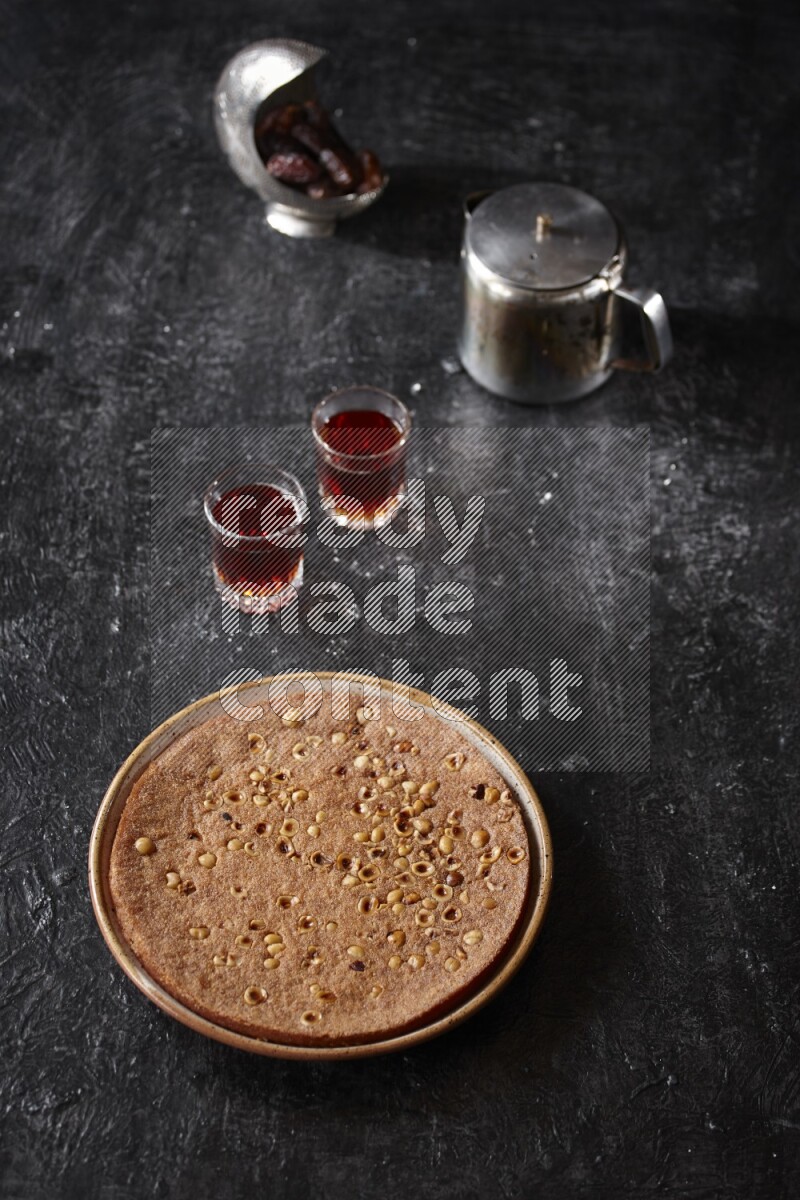 بسبوسة مع الشاي علي خلفية سوداء خشبية