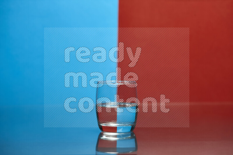 The image features a clear glassware filled with water, set against blue and red background