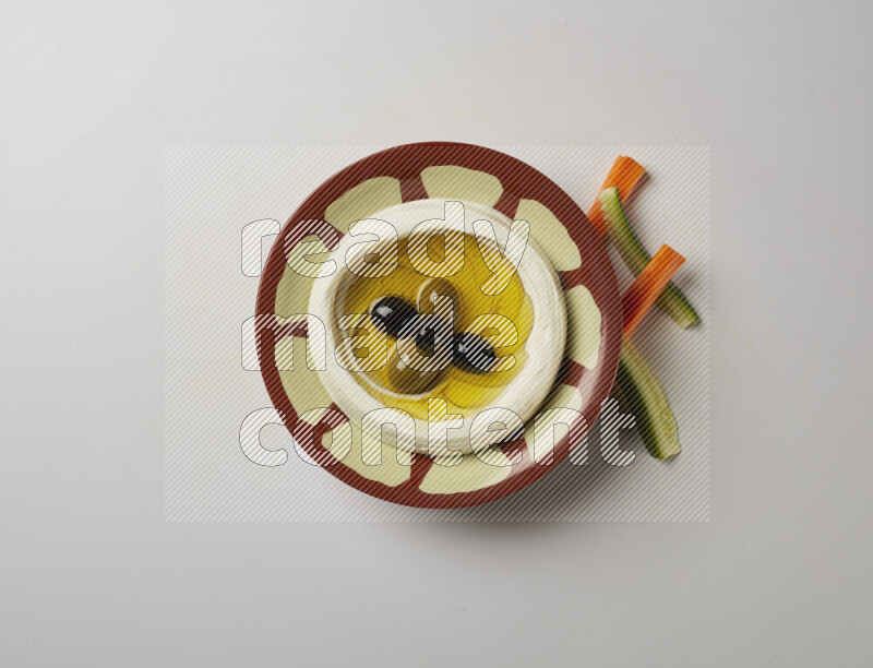 Lebnah garnished with olives in a traditional plate on a white background