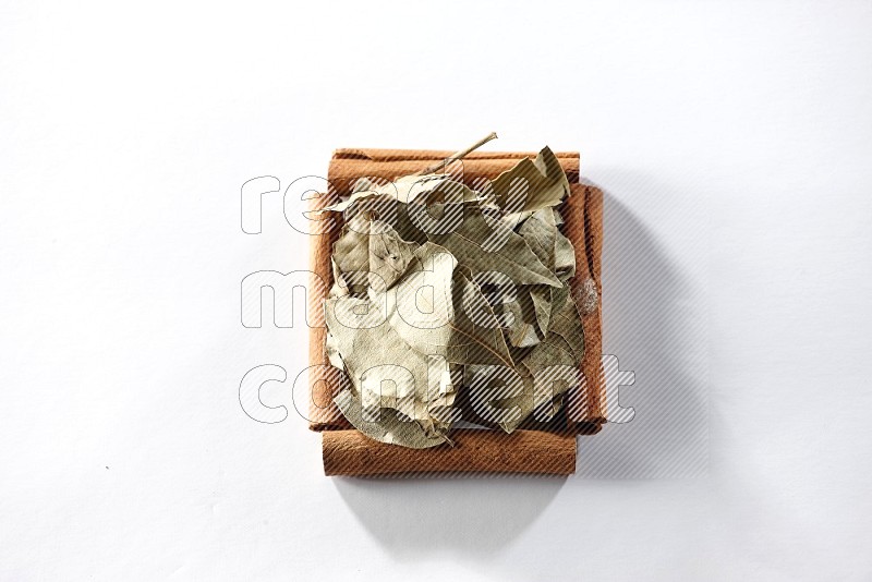 A single square of cinnamon sticks full of laurel bay on white flooring