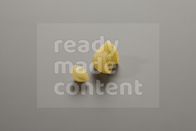 Shells pasta with other types of pasta on grey background