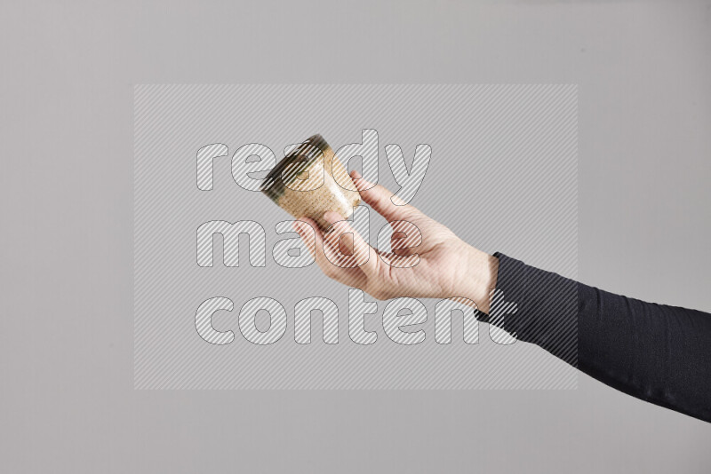 A woman in black abaya holding different pottery essentials in different positions