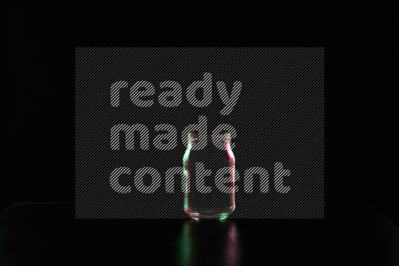 Glassware with rim light in red and green against black background