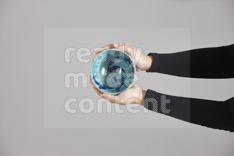 امرأة ترتدي عباءة سوداء تحمل أدوات فخارية مختلفة في أوضاع متعددة