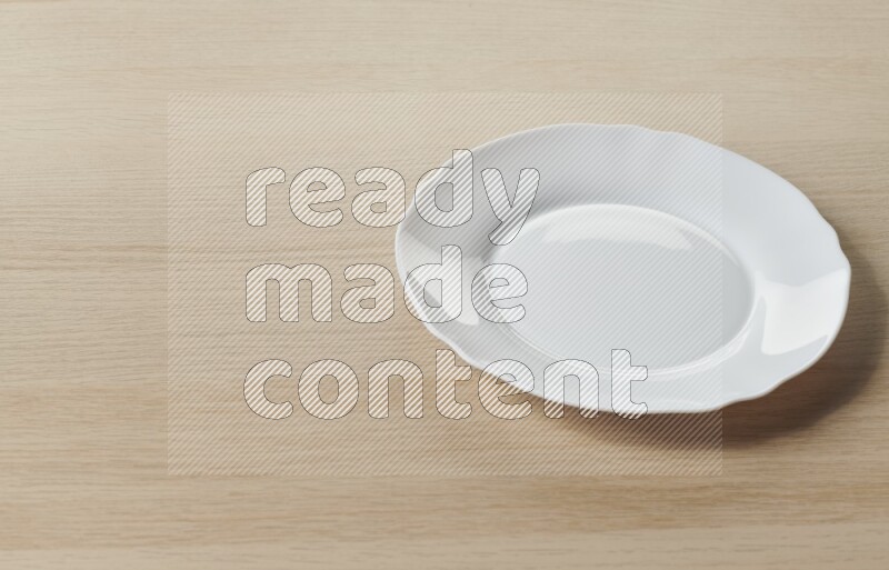 A white ceramic circular plate on light wooden background